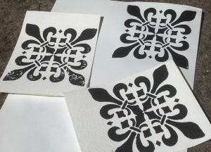 several sheets of paper with screen printed fleury crosses