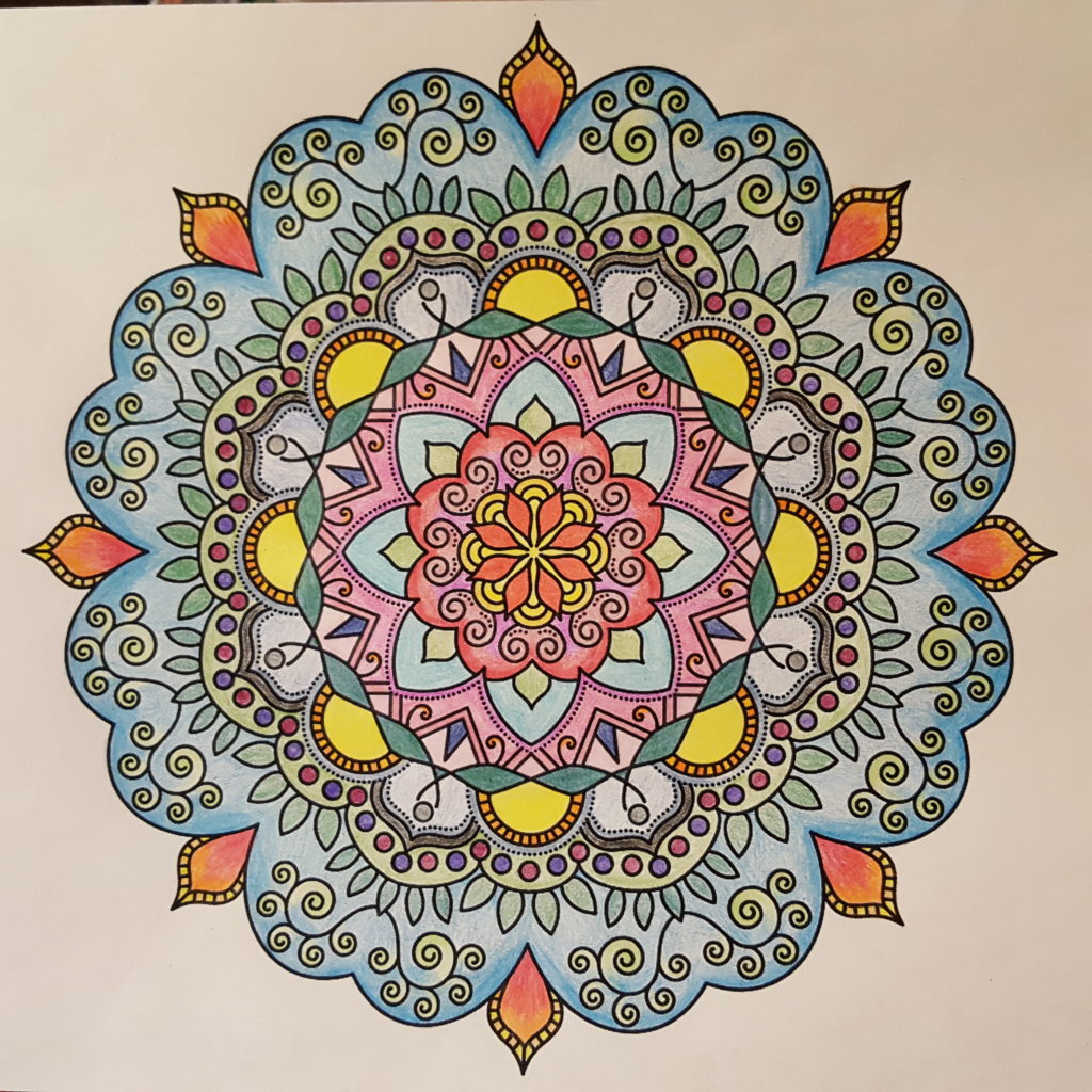 A design with 8-fold radial symmetry featuring flowers and shapes is colored in blues and greens with yellow, red, and orange details