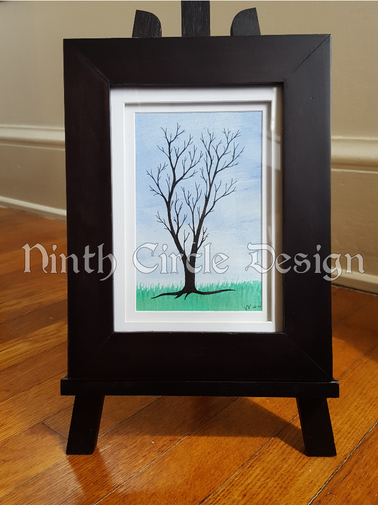 photograph of a framed painting/drawing of a leafless tree (drawn) against a background of blue sky and green grass (painted)